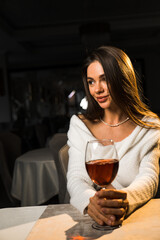 Young woman holding a glass of wine.Woman drinking wine in a restaurant.Red wine concept