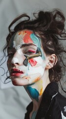 A studio portrait of a model with a painted face blurring the lines between human and artwork