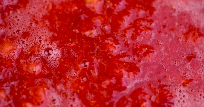 grated red ripe strawberries during cooking, juice and pieces of strawberries after pressing