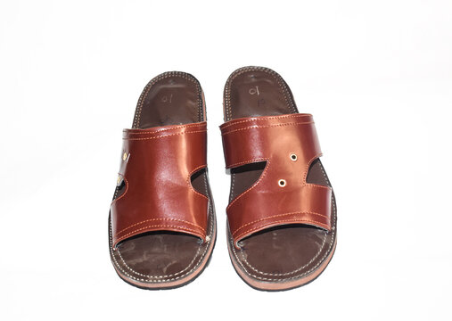 Stock photo of popular and traditional, handmade shoes chappal for male, Traditional footwear from Kolhapur, India, Kolhapuri Chappal showcasing on white wall