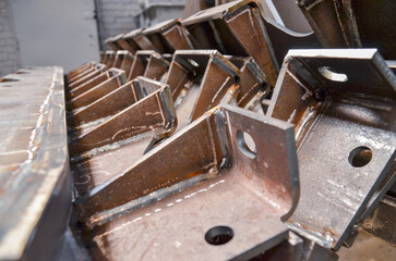 Preparation of welded parts for assembly of crawler dozers and wheel loaders. Storage station spare parts before painting components. Crawler bulldozer assembly line. Heavy industry.