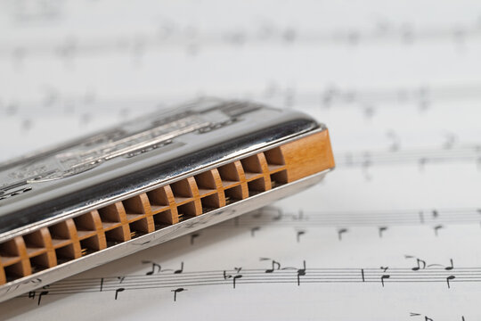 Mundharmonika und Musiknoten in einer Nahaufnahme