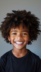 Cheerful child with curly hair smiling directly at the camera, exuding joy and innocence