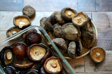 The Dried shiitake mushrooms on a wooden background.