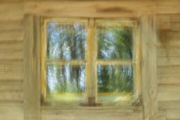 Intentional camera movement (ICM) of window on a wood plank wall on abandoned building, Päijänne, Finland.