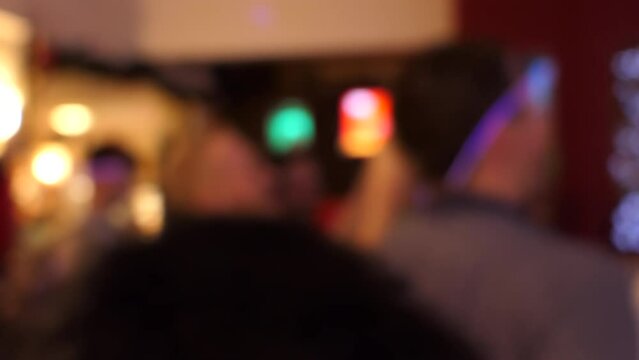 Blurred view of local English pub rock band playing and people dancing and clapping hands, handheld camera shot.