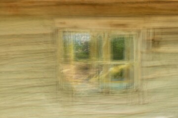 Intentional camera movement (ICM) of window on a wood plank wall on abandoned building, Päijänne, Finland.