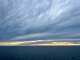 Naklejka na ściany i meble Dark cloudy sky at the ocean, deep blue seascape