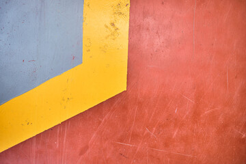 A yellow and red floor warning parking line on a textured floor inside a car park or industrial factory floor. dusty smooth and vibrant hazard warning.