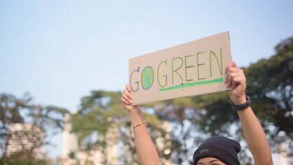 Go green people young woman hand raised showing save the earth planet world care banner poster sign in city nature tree sun light sunset. Plastic free issues Protect future asian hope net zero waste