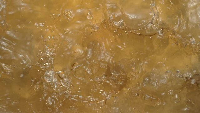 Splash of liquid texture with a yellowish tint. Texture of white wine or apple juice