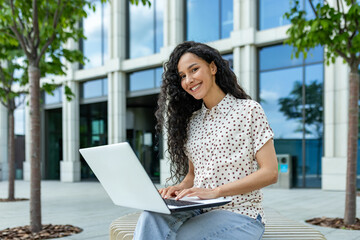 Focused professional working on a laptop in a casual outdoor setting, embodying modern work...