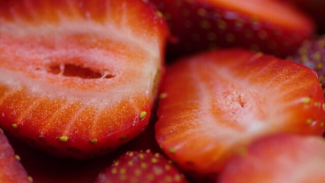 close-up of ripe strawberries cut into pieces and halves rotation. macro berries on a plate. ripe strawberry