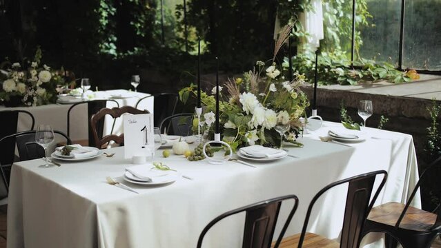 Long table with white tablecloth and chairs in a restauran. Wedding day