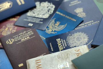 Many various passports of citizens of different countries and regions of the world close up - obrazy, fototapety, plakaty