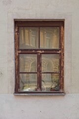 Fototapeta na wymiar Closeup of old weatherd brown wood frame window on stone building.