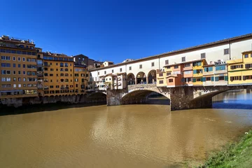 Papier Peint photo Ponte Vecchio Townhouses, buildings and the historic stone Ponte Vecchio bridge on the Arno River in the city of Florence