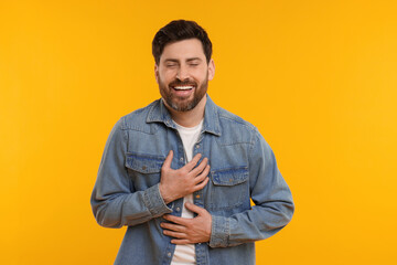 Portrait of handsome man laughing on yellow background