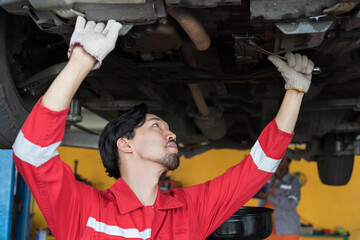 Male mechanic working at garage. Professional Asian male mechanics checks, repair and maintenance...