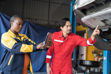 Male and female mechanic working at garage. Professional mechanics checks, repair and maintenance...