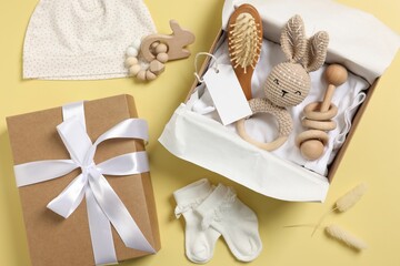 Flat lay composition with different baby accessories and blank card on yellow background