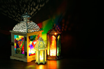 Decorative Arabic lanterns on table against dark background. Space for text