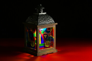Decorative Arabic lantern on table against dark background