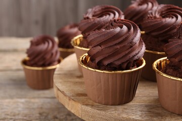 Delicious chocolate cupcakes on wooden table, closeup