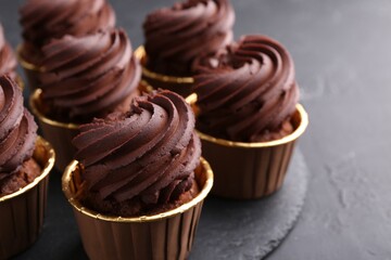 Delicious chocolate cupcakes on black table, closeup