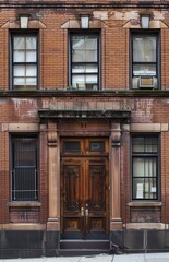 Side of an old house with brick wall with wooden windows.