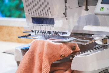 Automatic sewing machine for embroidering patterns and designs on clothes using computer technology. - obrazy, fototapety, plakaty
