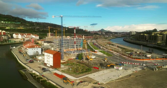 Obras con muchas gruas en la ciudad al amanecer.