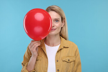 Woman with air balloon on light blue background