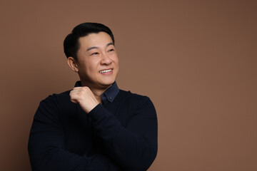 Portrait of happy man on brown background. Space for text