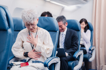 飛行機の機内で体調不良に苦しむ高齢の女性 - obrazy, fototapety, plakaty