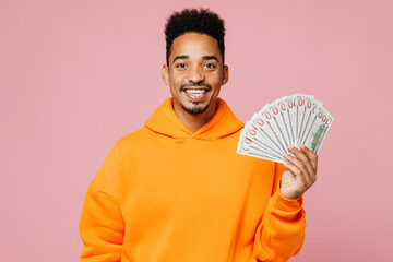 Young happy man of African American ethnicity wear yellow hoody casual clothes hold fan cash money...