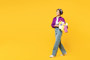 Full body sideways young smiling happy woman wear casual purple shirt do housework tidy up hold...