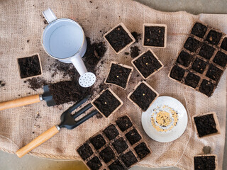 gardening tools with compostable pots filled with soil and seeds for planting seeds