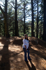 a woman observing the tops of the trees in a forest in southern Chile