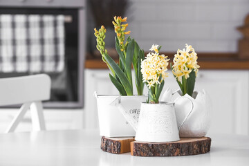 Spring hyacinth flowers on a white table. In the background is a white Scandinavian-style kitchen....