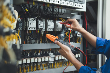 Electrician measurements with multimeter testing current electric in control panel, safety concept .
