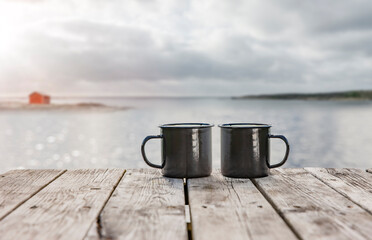 Zwei Kaffeetassen auf einem Holztisch an der Küste von Schweden