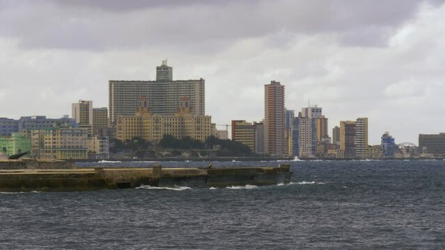 Havana skyline and famous Malecon seawall in Cuba. Cityscape of Havana, Cuba capital city and Malecon promenade, Bahia de la Habana bay. View of city and ocean from old fort, Havana, Cuba. Slow motion
