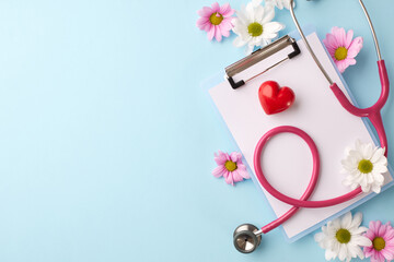 Caring for health: overhead view of a stethoscope, red heart, clipboard, and fresh flowers on a...