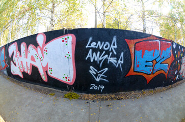 Fisheye shot of street art graffiti drawing on wall. Spray art artwork with different colors and outlines. Illegal vandalism concept