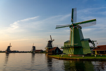 Fototapeta na wymiar Windmills in the beautiful village of Zaanse Schans in Netherlands at sunset
