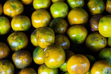 A bunch of oranges are piled up in a crate