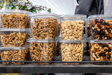 Shelled nuts and almonds and mixed nuts in clear plastic boxes displayed for sale in supermarket