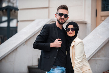 A young happy Muslim fashionable couple posing outside.