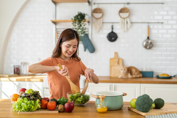 Obraz na płótnie Canvas Portrait of beauty body slim healthy asian woman eating vegan food healthy with fresh vegetable salad in kitchen at home.diet, vegetarian, fruit, wellness, health, green food.Fitness and healthy food